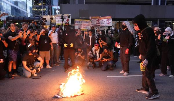 抗议者在以色列领事馆附近焚烧国旗，2024年8月20日，芝加哥民主党全国代表大会期间。 (美联社)