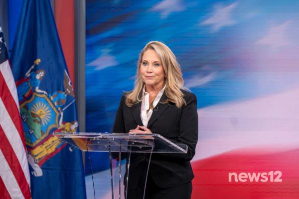 Woman standing at a podium with GOP Rep. Anthony D'Esposito and Dem Laura Gillen, courtesy of News 12