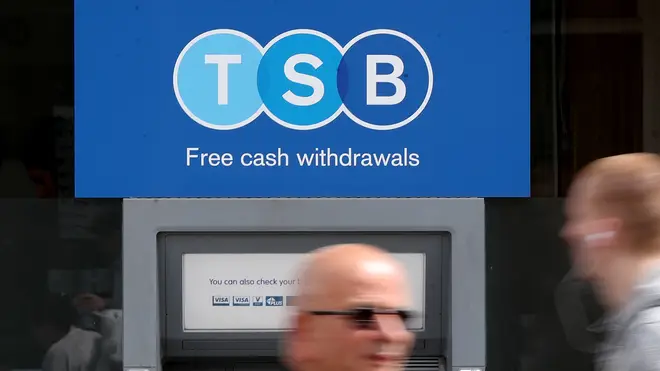 People walk past a TSB cash machine